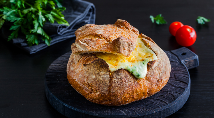 Dip of three cheeses and spinach in a bread loaf