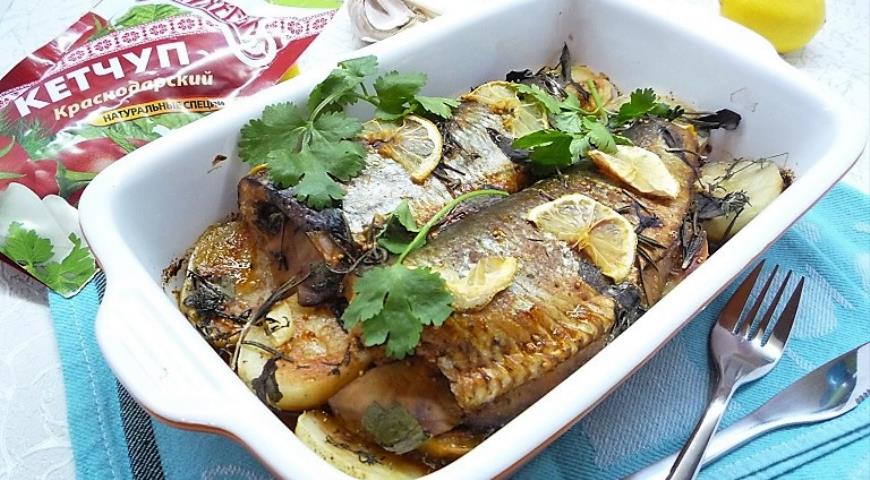 Herring with potatoes under tomato marinade in the oven.