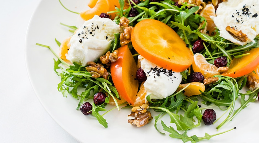 Salad with cheese, persimmon, nuts and poppy seed dressing